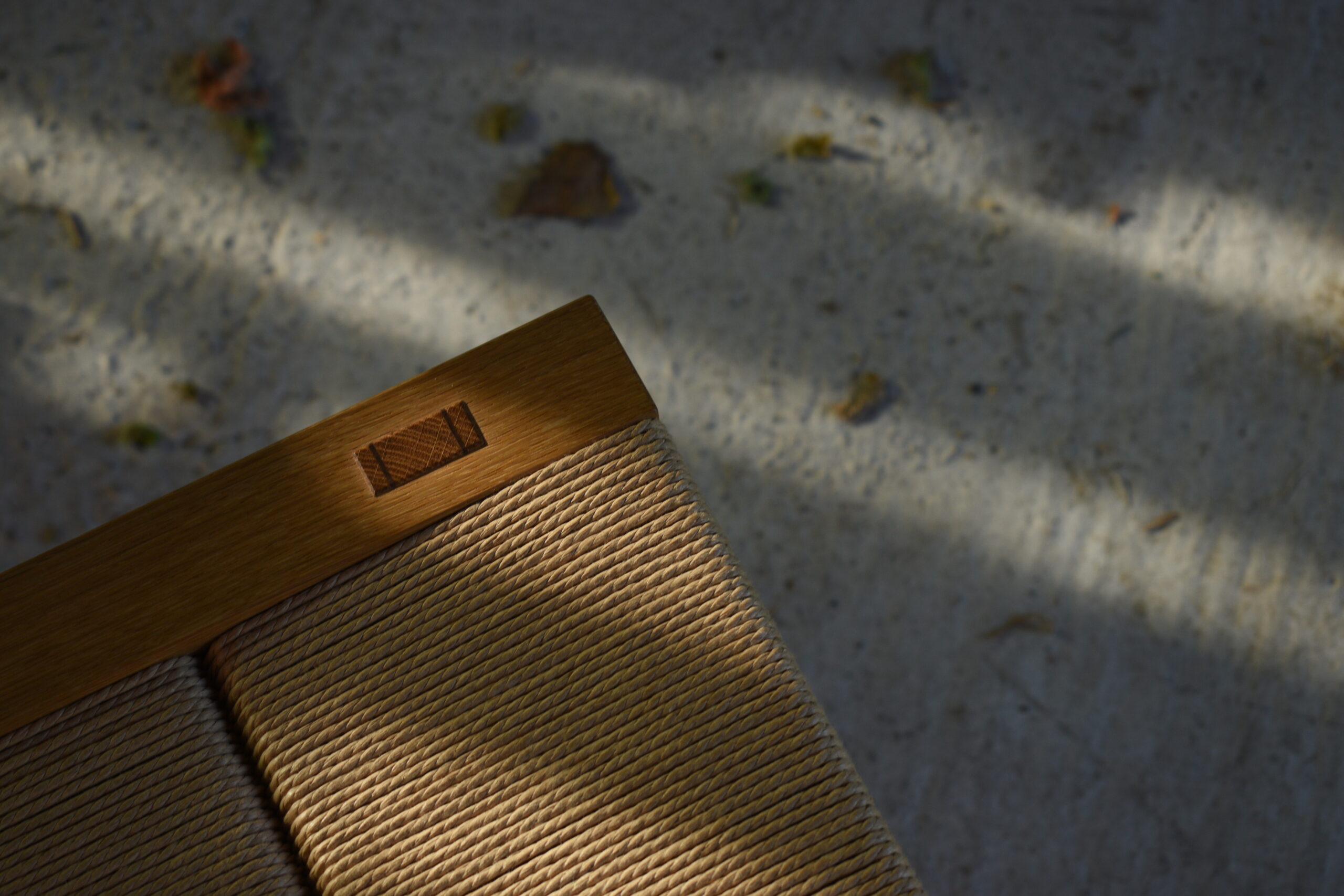 A detail on an oak stool with paper cord seat